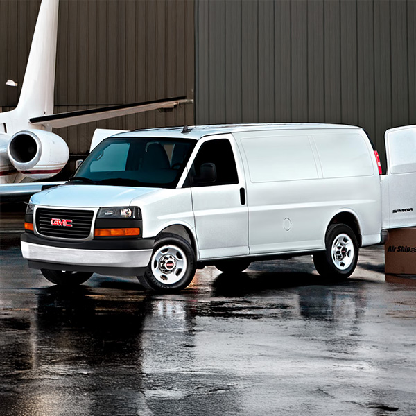 Front 3/4 shot of the 2025 GMC Savana Cargo Van parked in a hangar