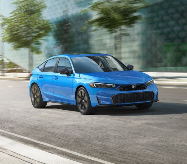Blue 2025 Honda Civic Hatchback racing down a road