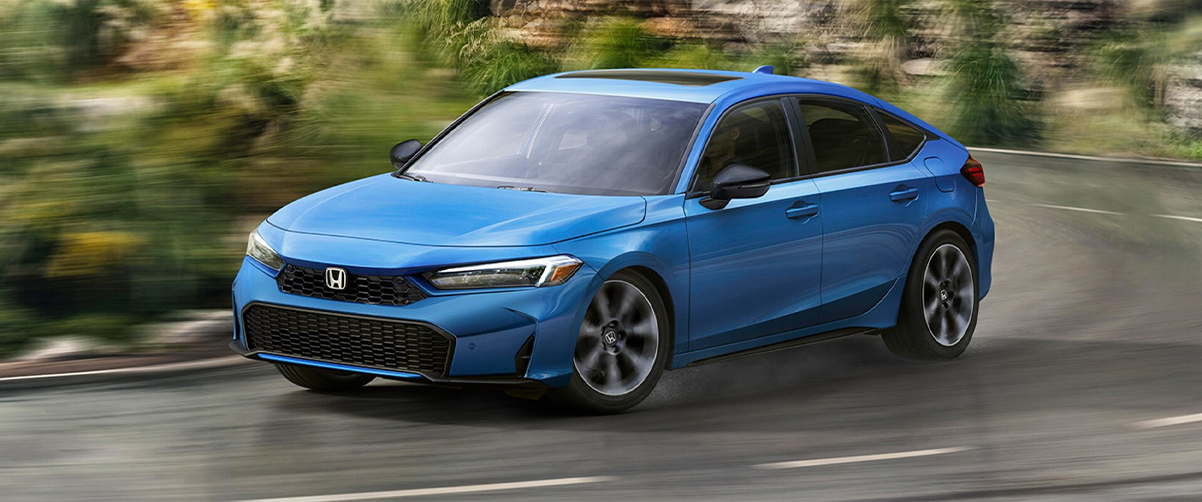 Blue 2025 Honda Civic Hatchback racing down a road
