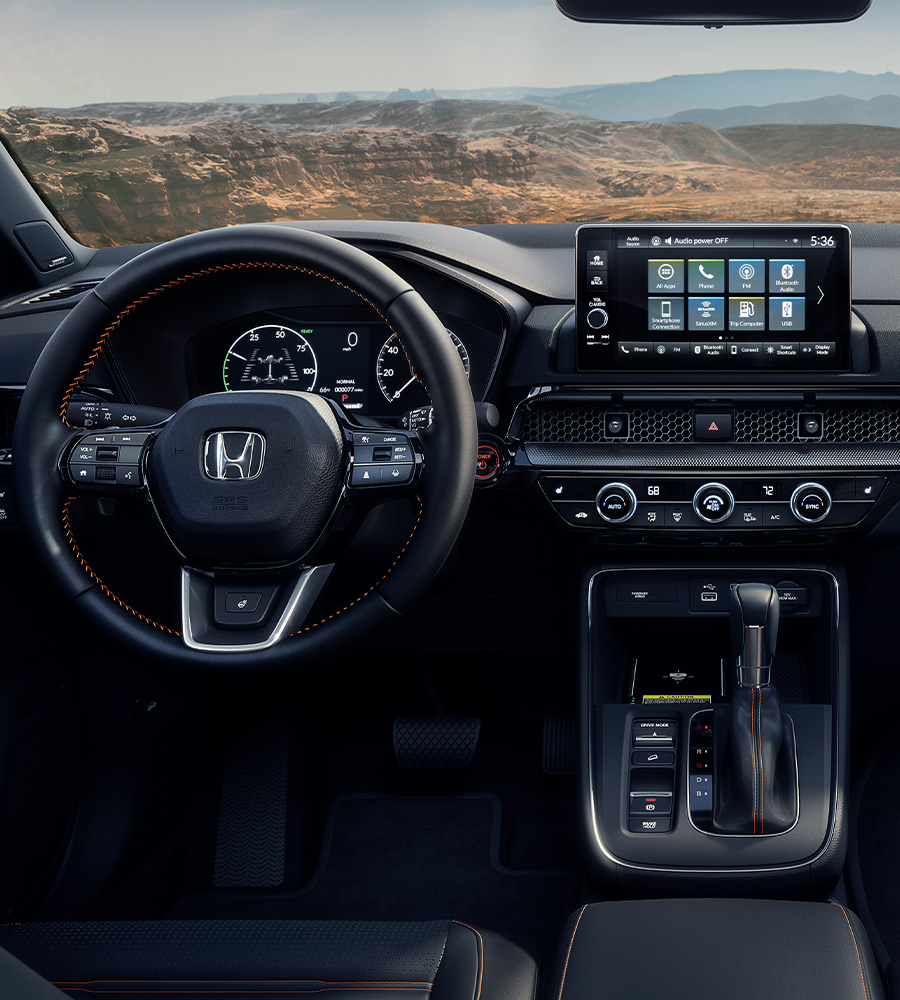 Interior view of the 2025 Honda CR-V Sport Touring Hybrid with Black Leather, with desert canyon landscape visible through the windshield.