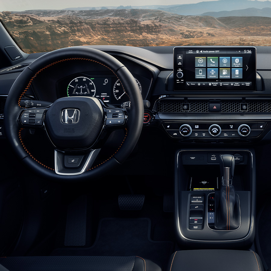 Interior view of the 2025 Honda CR-V Sport Touring Hybrid with Black Leather, with desert canyon landscape visible through the windshield.