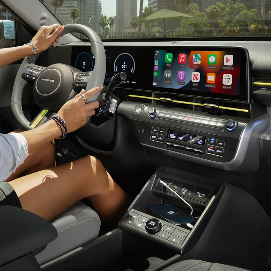 A woman driving a 2025 Kona Electric