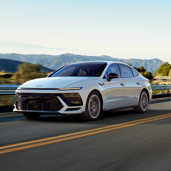2025 Sonata N Line driving on road with mountains in the background
