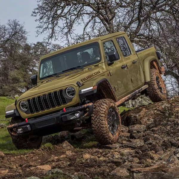 An olive green 2025 Jeep Gladiator Rubicon X descending a rugged, rocky trail off-road.