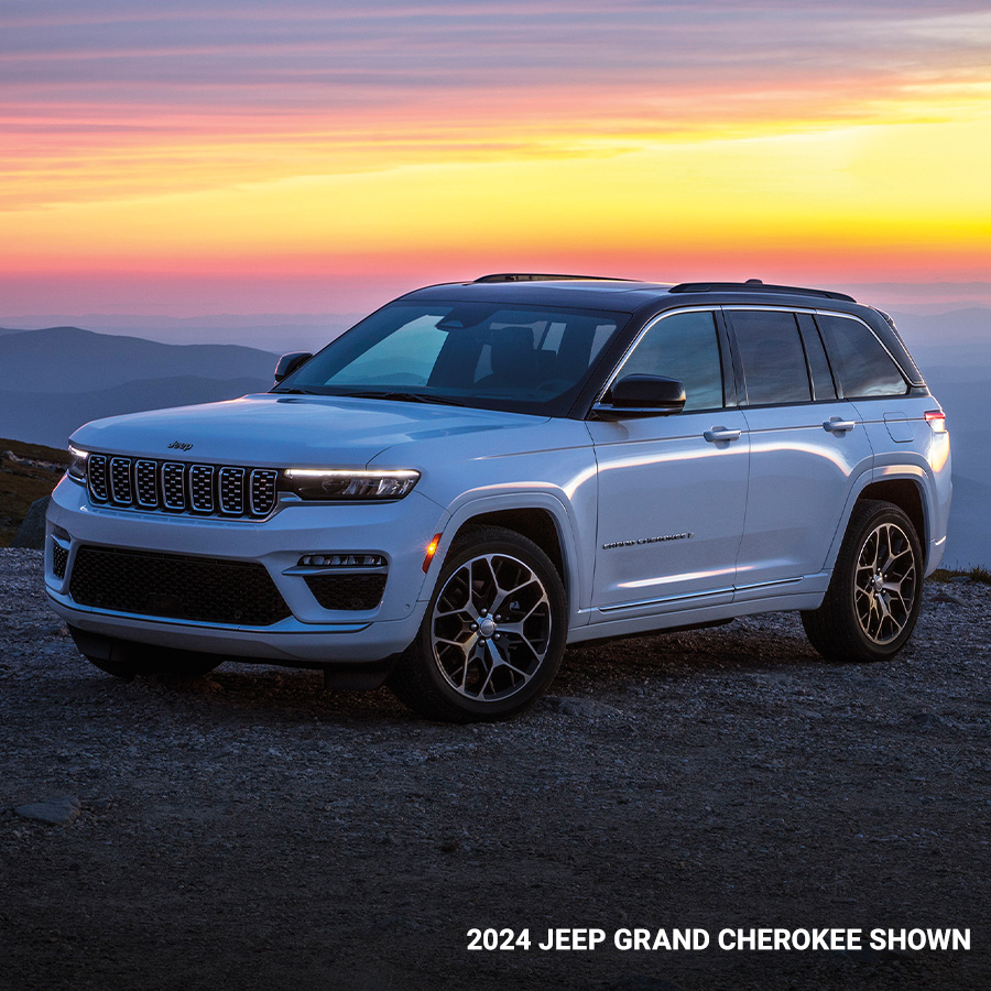 2024 Grand Cherokee Summit Reserve in Bright White parked overlooking foggy mountains in the distance.