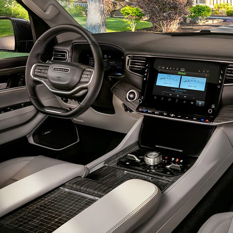 Display The front row of the 2025 Jeep Wagoneer Series III cabin, focusing on the seats, steering wheel, touchscreen and dash.