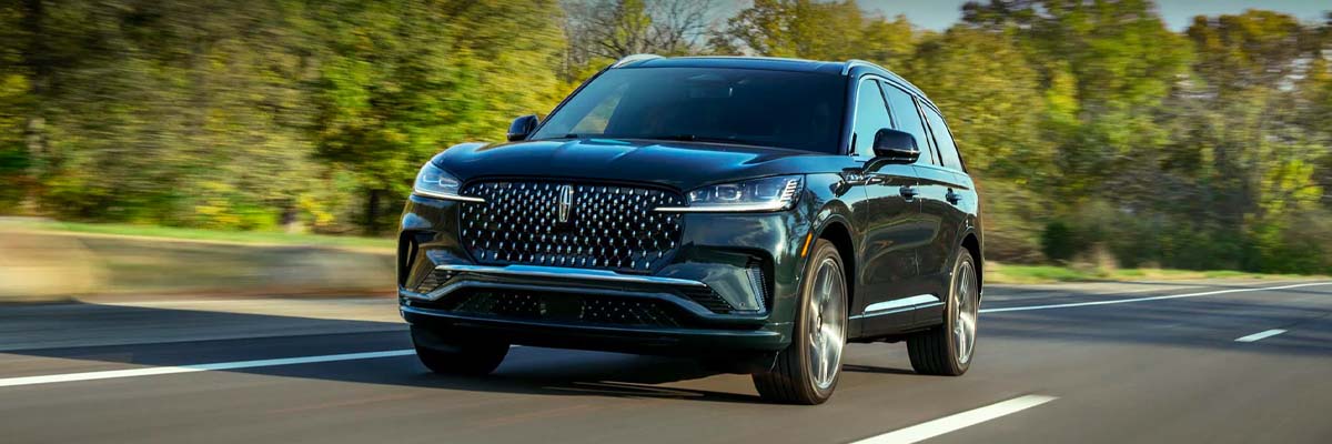 Brand New 2025 Lincoln Aviator driving on a foresty highway