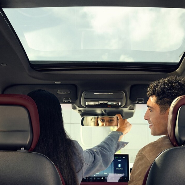 The driver of a 2025 Lincoln Corsair® Reserve model adjusts the frameless rearview mirror