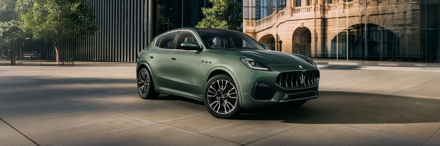 025 Maserati Grecale luxury compact SUV in deep metallic green, parked on a city street with modern architecture in the background.