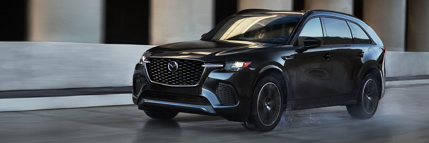 2025 Mazda CX-70 driving on a city road.