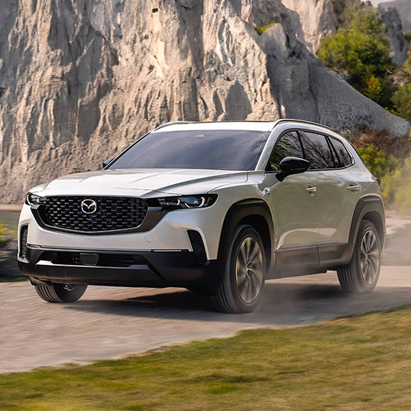 2025 MAZDA CX-50 Hybrid driving on a dirt road.
