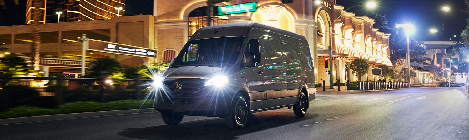 Front 3/4 shot of the 2025 Mercedes-Bezn eSprinter Van driving down city street