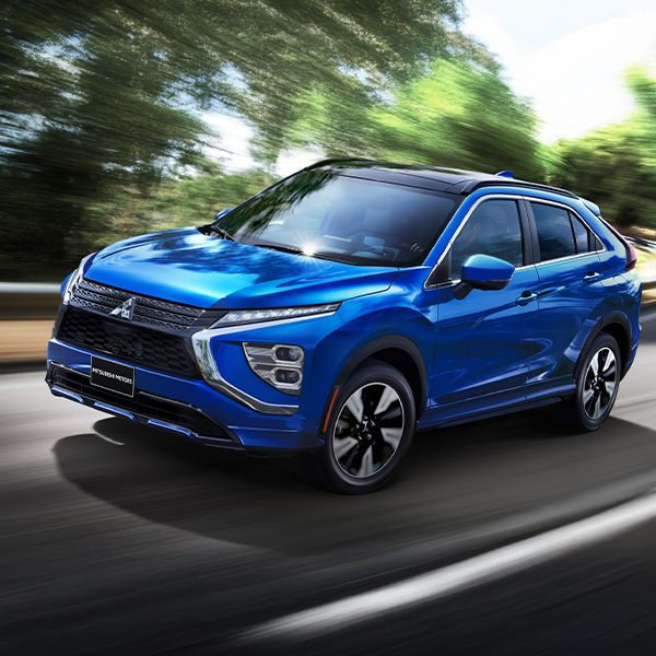 Action shot of the 2025 Mitsubishi Eclipse Cross driving down a scenic road
