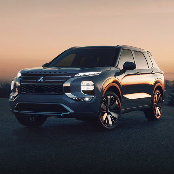 The 2025 Outlander parked in front of a city.