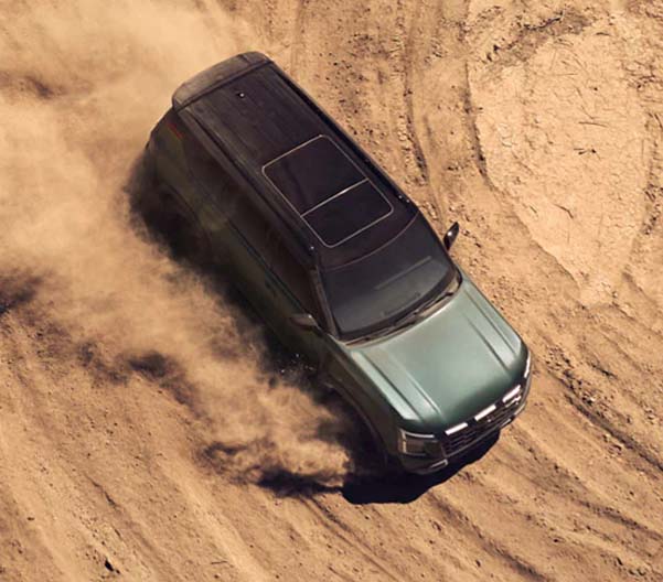 Aerial view of a green 2025 Nissan Armada racing along a dirt path