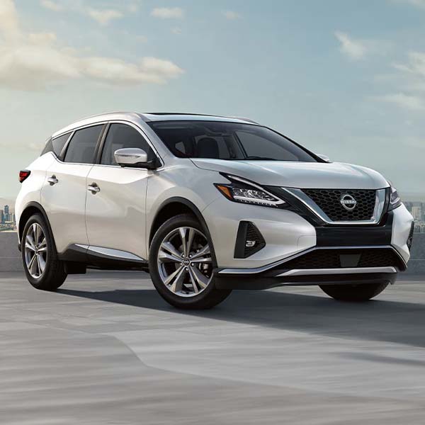 2025 Nissan Murano parked in lot with cityscape in the distance.