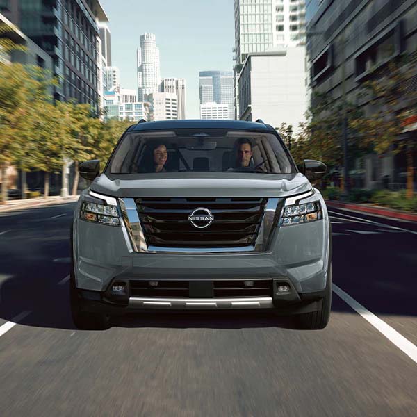 2025 Nissan Pathfinder driving down city street.