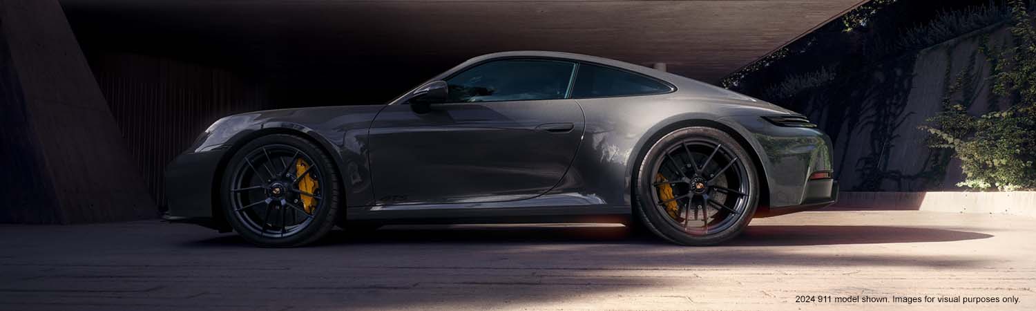 Side profile of a Porsche 911 parked in front of a beautiful modern house