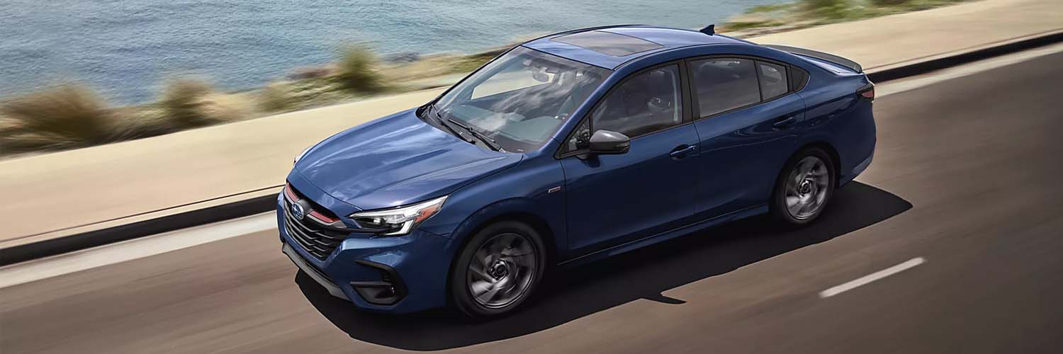 Blue 2025 Subaru Legacy racing down a road