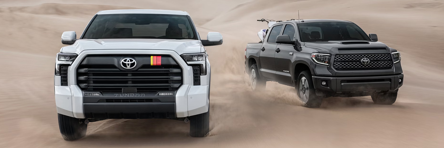 Two Toyota Tundras driving in a desert side by side.