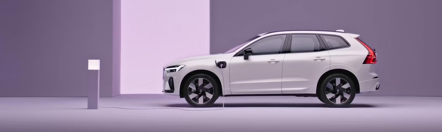 A Volvo XC60 plug-in hybrid, charging in a purple surrounding.