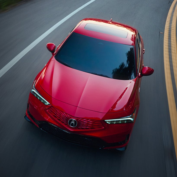 Overhead 3/4 shot of the 2026 Acura Integra driving down road
