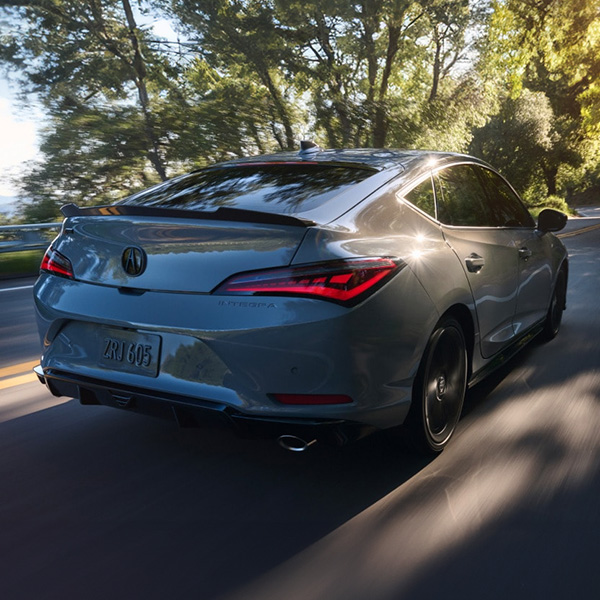 Rear 3/4 shot of the 2026 Acura Integra driving down road