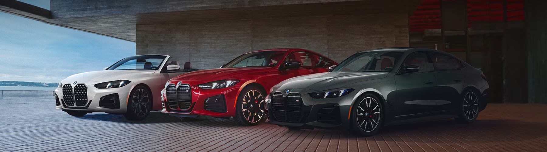 The 4 Series Coupe, the 4 Series Convertible, and the 4 Series Gran Coupe parked together on the top deck of a garage