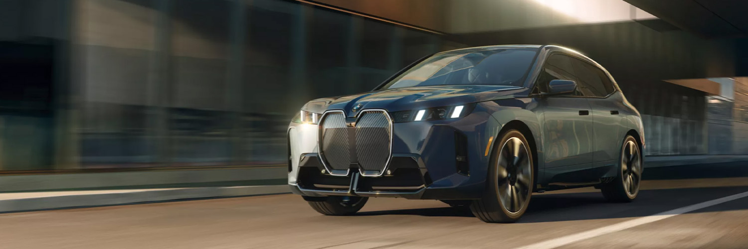 2026 BMW iX driving down city street