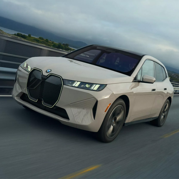White 2026 BMW iX driving on highway