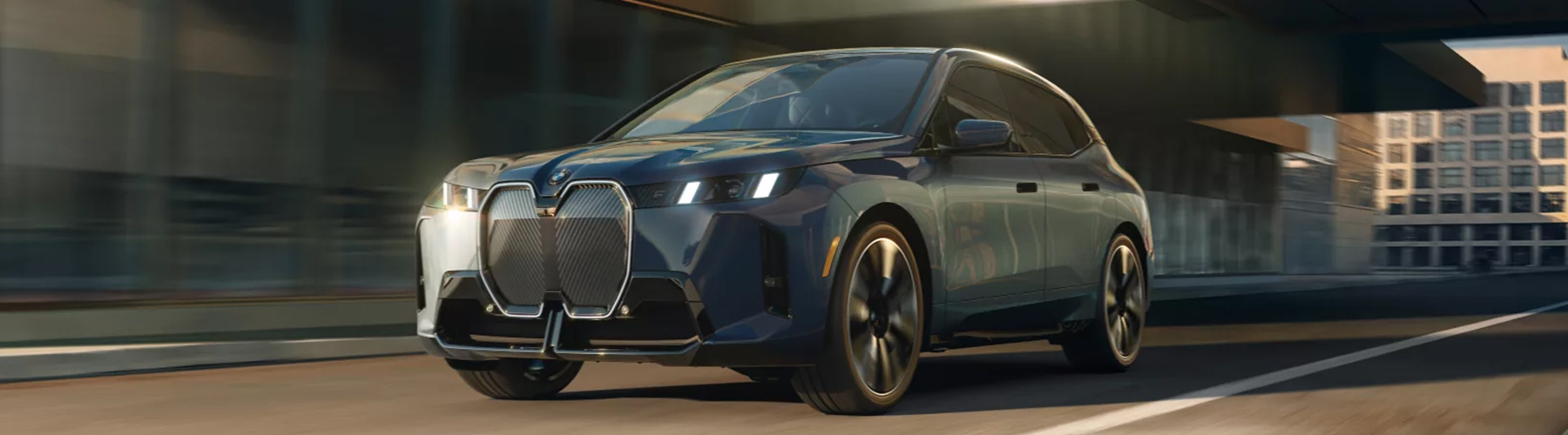 2026 BMW iX driving down city street
