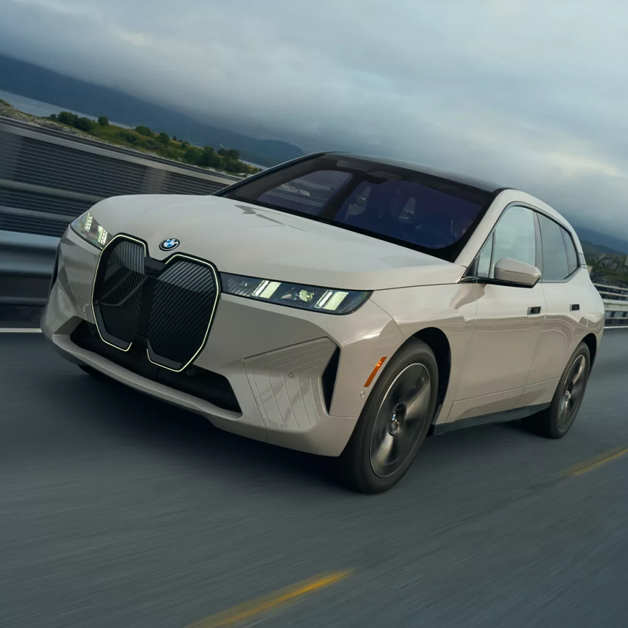 White 2026 BMW iX driving on highway