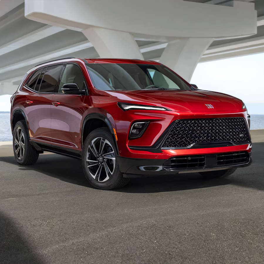 Three-Quarters View of a Red 2025 Buick Enclave ST with a Lake in the Distance.