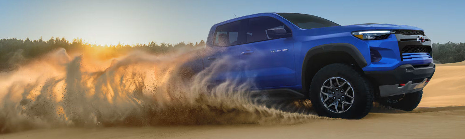 Three Quarters View of a Blue 2026 Chevy Colorado Pickup Truck Driving in the Desert