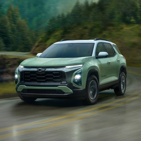 2026 Chevy Equinox driving on forest road in the rain.