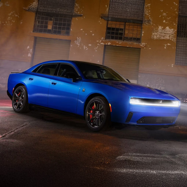 2026 Dodge Charger parked outside of industrial building with headlights on
