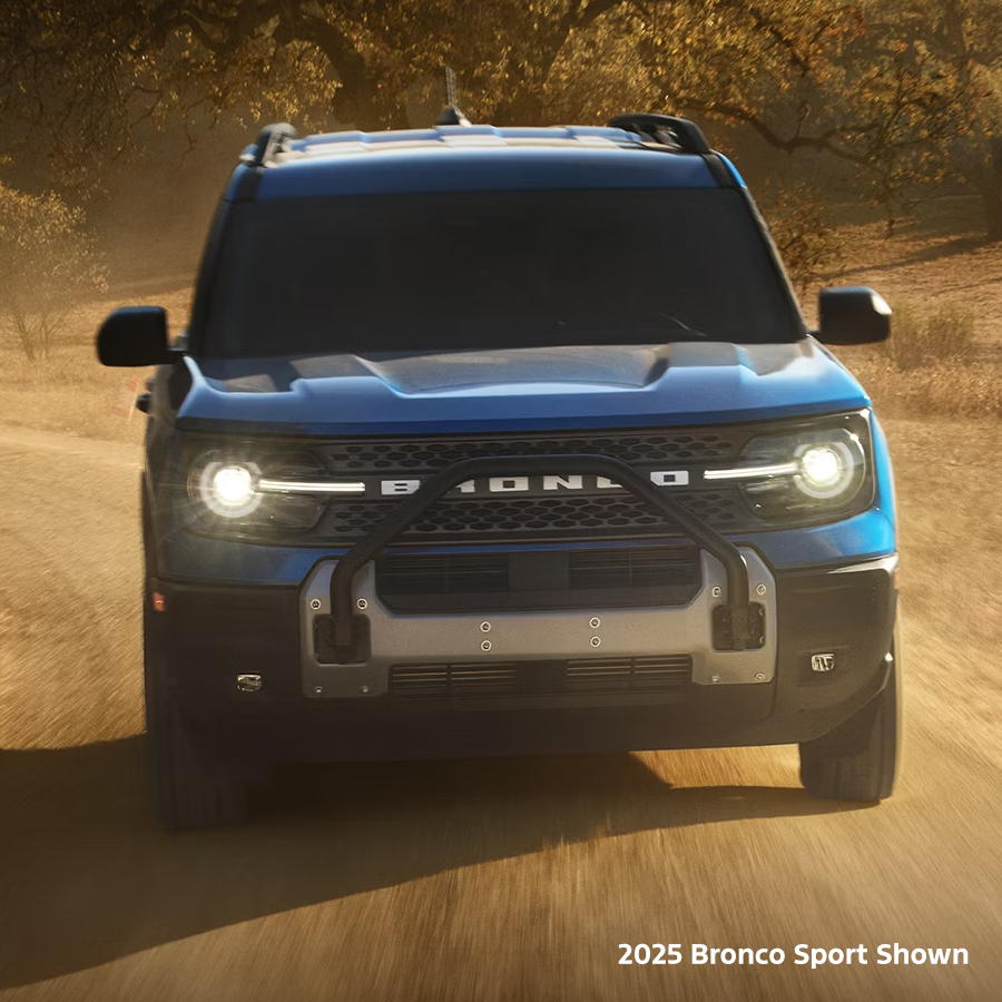 A blue 2025 Ford Bronco Sport® Big Bend® being driven across a gravel road