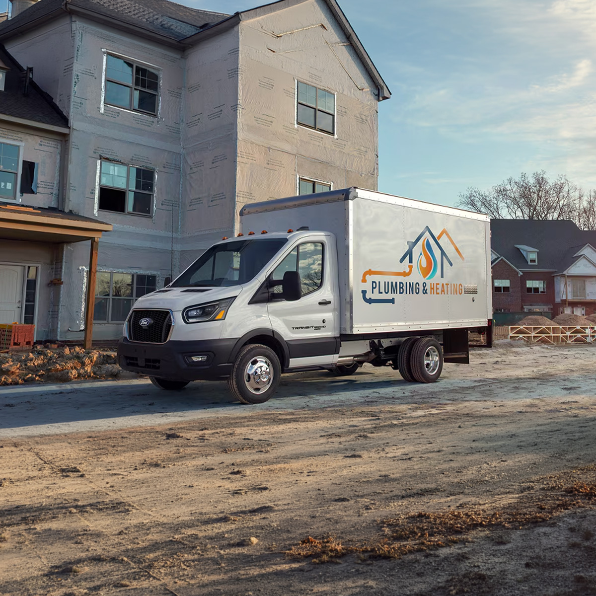 2026 Transit Chassis Cab with a Plumbing & Heating logo parked in front of a home under construction