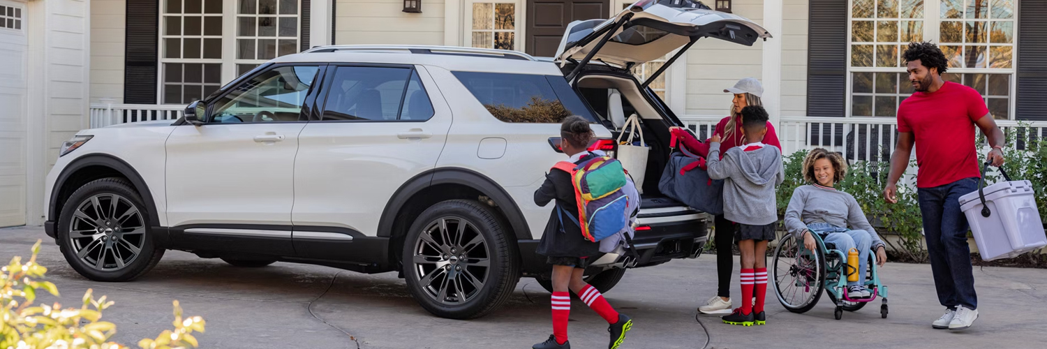 A family packing luggage into the rear of a 2026 Ford Explorer® SUV