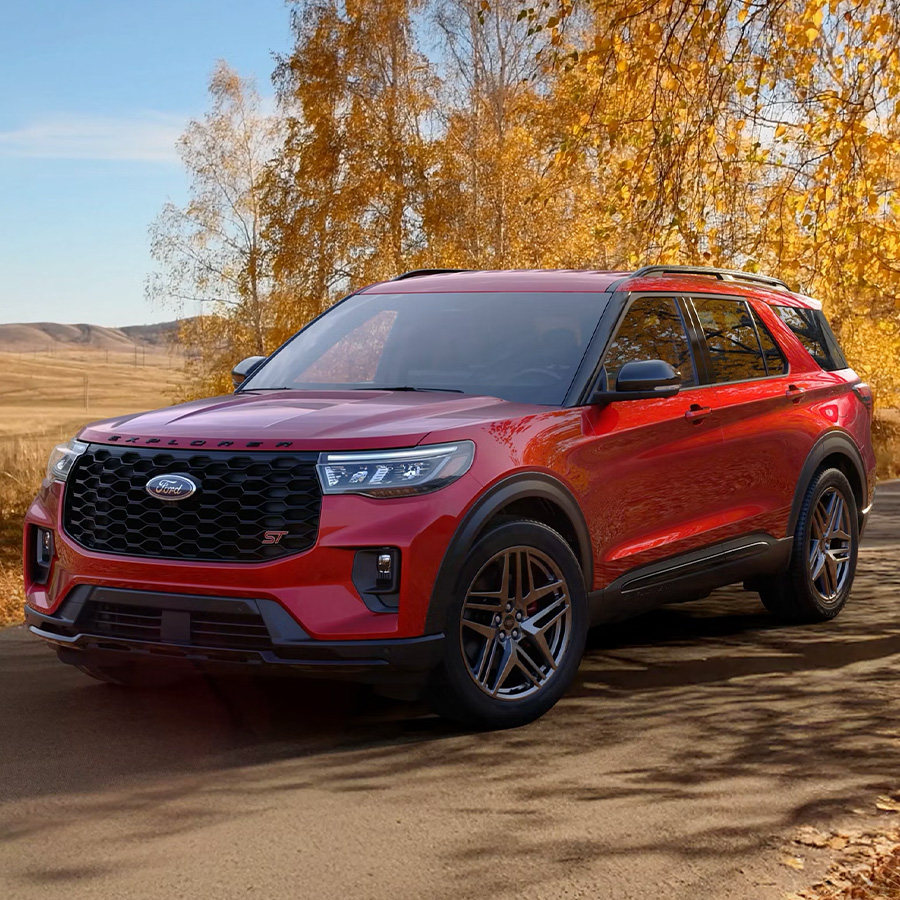 A 2026 Ford Explorer® SUV on a road through a field in the fall