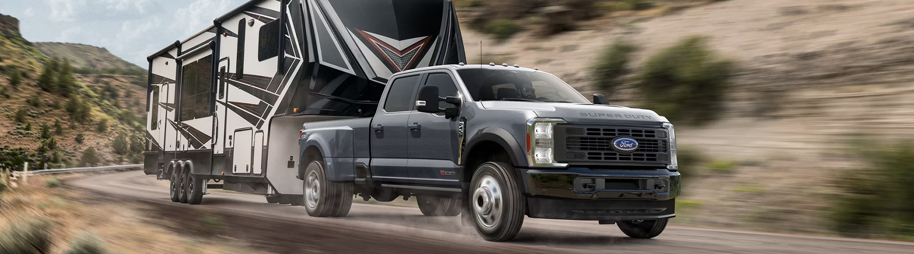 Ford Super Duty® F-450® XL in Carbonized Gray pulling a camper down a winding road