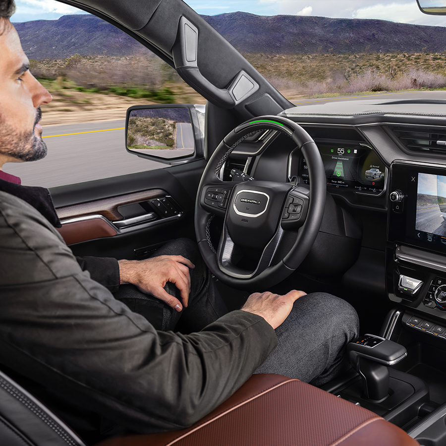Profile View of a Name Driving the 2026 GMC Sierra 1500 Pickup Truck Using the Super Cruise Hands-Free Driving Technology