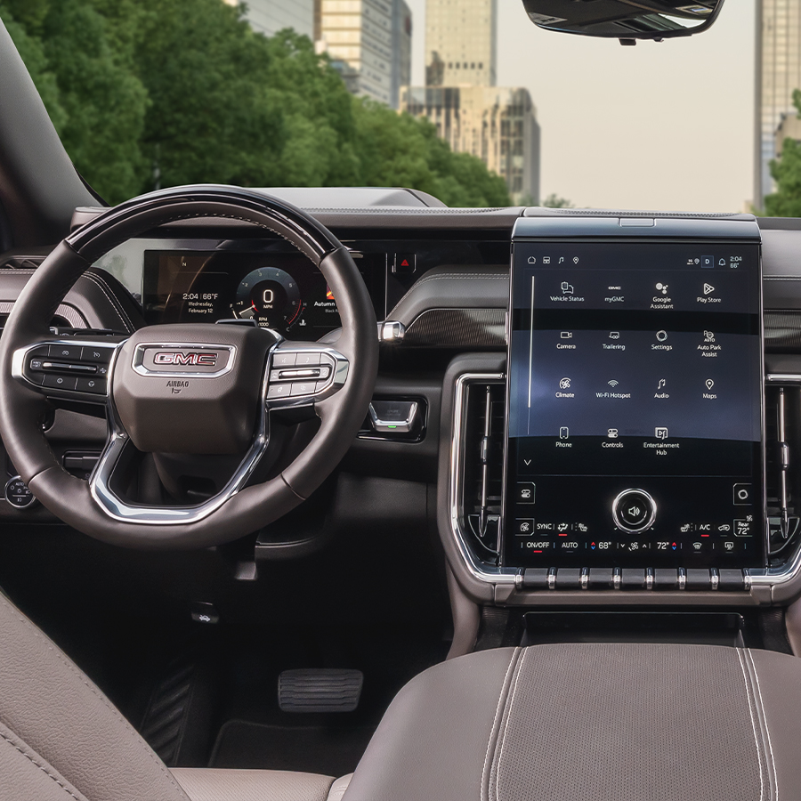 2026 GMC Yukon Elevation rear view to front of vehicle with screen and city in view