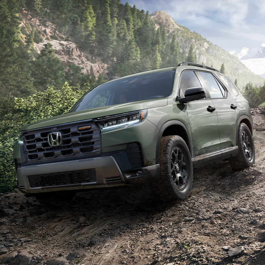 Front 3/4 shot of the 2026 Honda Pilot driving down dirt road