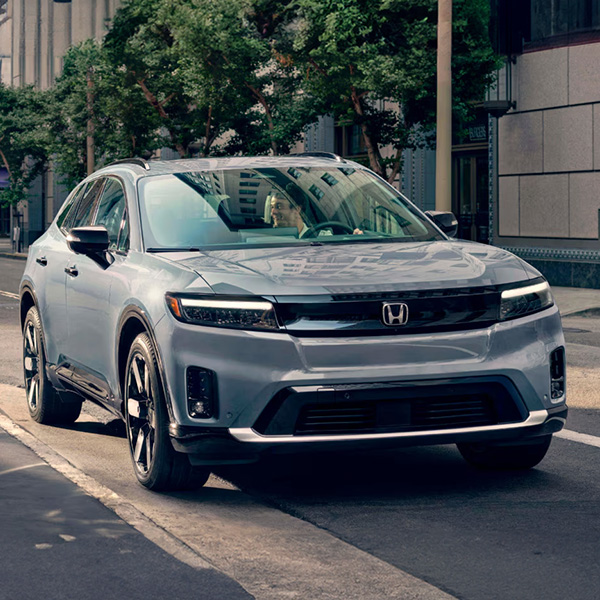 2026 Honda Prologue driving on a scenic road.