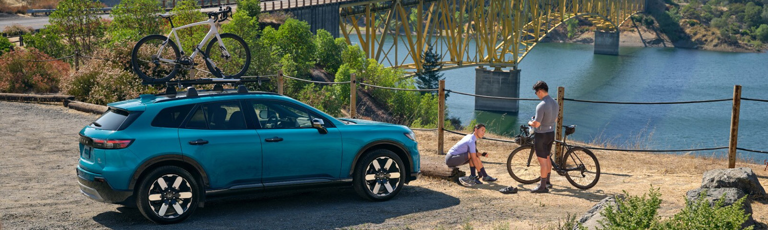 2026 Honda Prologue parked near a modern home with a charger.