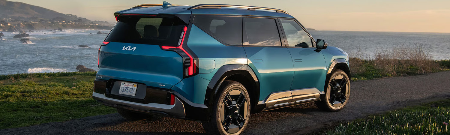 Blue 2026 Kia EV9 parked along a cliffside road