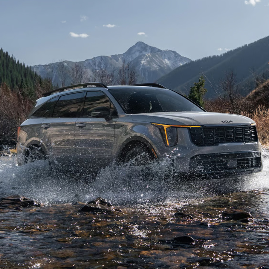 2026 Kia Sorento, three-quarter view, driving through a river making a big splash