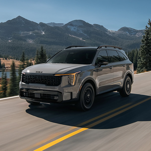 2026 Kia Sorento driving on a road past a mountian range