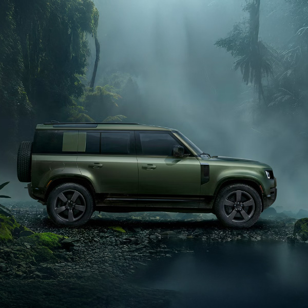 Side view of the 2026 Defender 110 parked in a rainfores.t